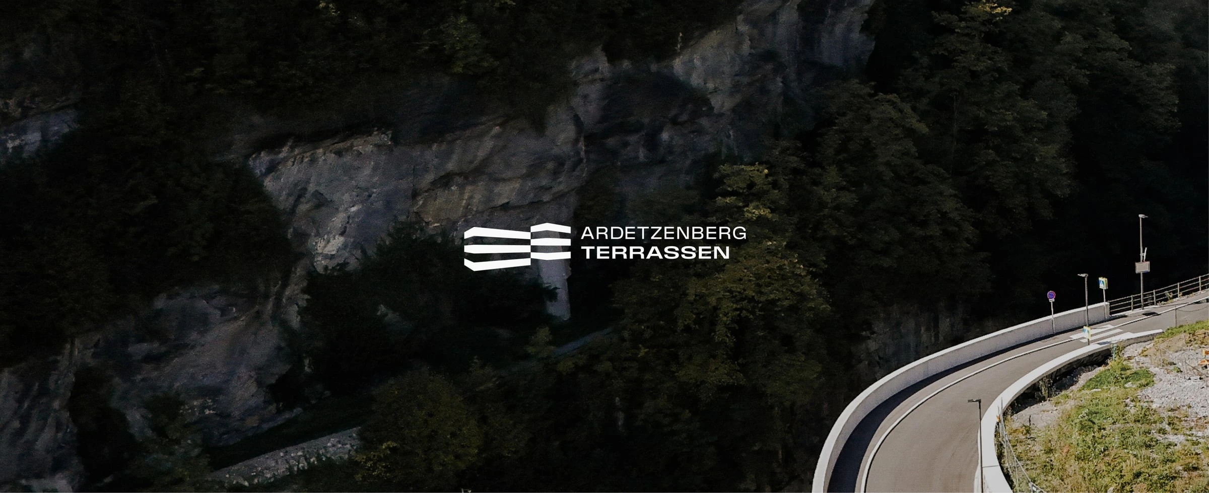 Logo von Ardetzenberg Terrassen über einer Felswand mit Straße